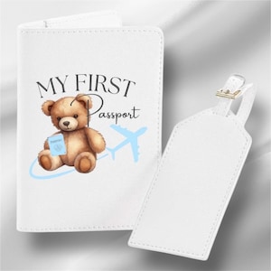 May include: White passport holder with a blue airplane and a brown teddy bear holding a passport. The text "MY FIRST Passport" is printed on the front. A white luggage tag is included.