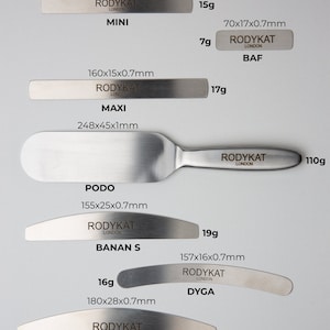 May include: Set of 7 stainless steel nail foot base files in various sizes and shapes. The files are labelled with their dimensions and weight in grams. The labels also include the brand name "RODYKAT LONDON" and the name of the file, such as "MINI", "MAXI", "PODO", "BANAN S", "BAF", "DYGA", and "BANAN".