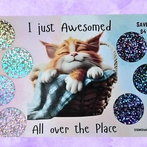 May include: A greeting card with a cartoon cat sleeping in a basket. The card has a glittery design and says "I just Awesomed All over the Place".