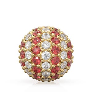 May include: A gold-colored sphere covered in alternating red and white gemstones. The gemstones are evenly spaced across the surface, creating a textured, jewel-toned appearance. The sphere is set against a plain white background.