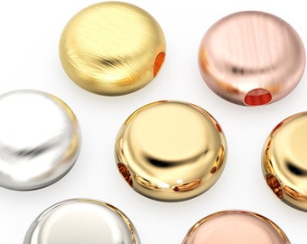 May include: A set of six round metal beads in different finishes: gold, rose gold, silver, and brushed silver. The beads have a smooth, rounded surface and a small hole in the centre.