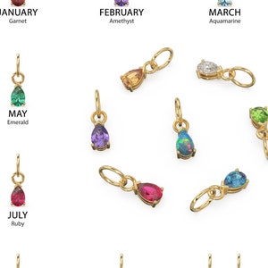 May include: Gold pendants with teardrop-shaped gemstones representing birthstones for each month. The image includes pendants with Garnet, Amethyst, Aquamarine, Diamond, Emerald, Moonstone, Ruby, Peridot, Sapphire, Opal, Topaz/Citrine, and Zircon.