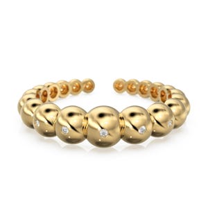 Può includere: Un bracciale aperto color oro con una serie di grandi perle rotonde. Ogni perla ha un piccolo accento di diamante scintillante. Il bracciale è progettato per avvolgersi attorno al polso, mostrando un gioiello moderno ed elegante.