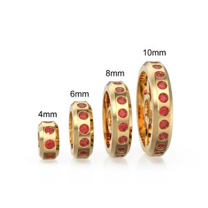 May include: Four gold rings with red gemstones set in the band. The rings are in different sizes: 4mm, 6mm, 8mm, and 10mm.