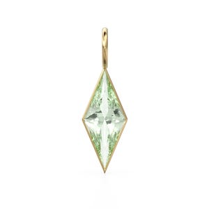 May include: A gold pendant with a light green, diamond-shaped gemstone. The gemstone is faceted and set within a gold frame. The pendant has a small gold loop at the top for a chain.