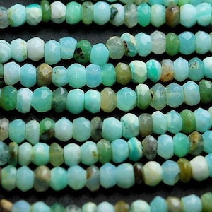 May include: A strand of light blue and green gemstone beads. The beads are faceted and have a slightly irregular shape.