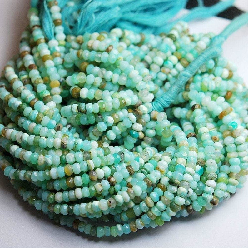 May include: A strand of turquoise and green opal beads. The beads are faceted and have a slightly irregular shape. The strand is approximately 40 cm long and is perfect for making jewellery.
