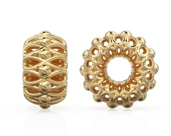 Peut inclure: Deux perles de bijoux dorées. L'une est cylindrique avec un motif répétitif de lignes et de sphères entrelacées. L'autre est une perle circulaire avec un motif floral, comportant de multiples ouvertures arrondies. Les deux perles sont très réfléchissantes.