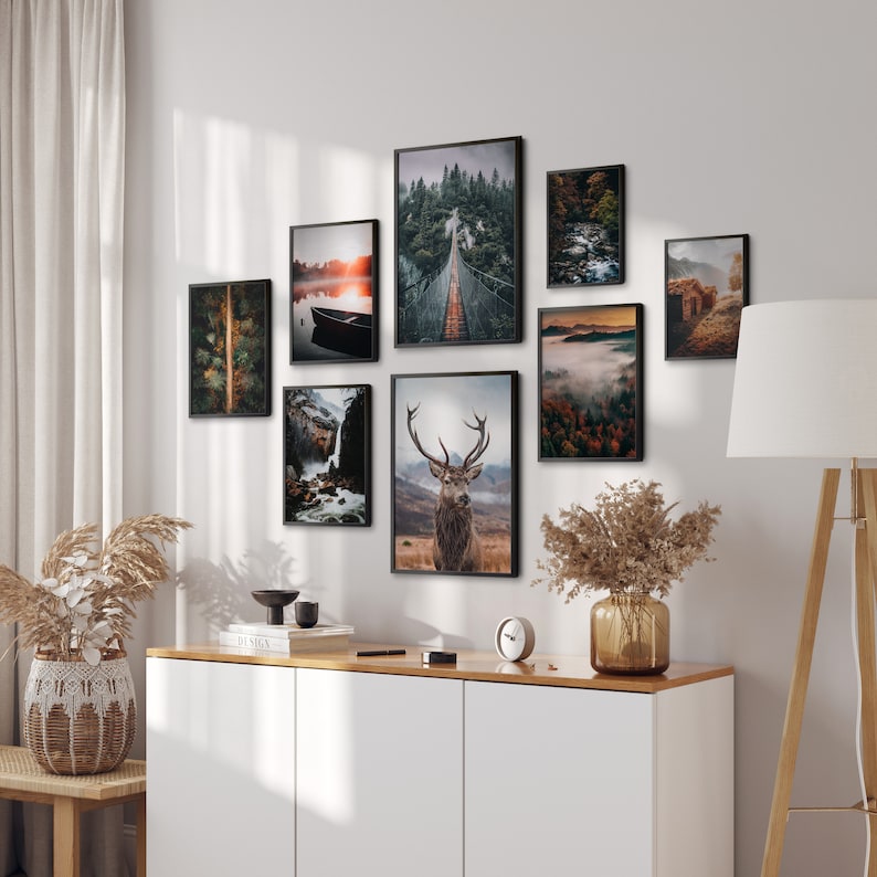 May include: A gallery wall of framed nature photographs, including a deer, a bridge in a forest, a lake with a boat, a waterfall, and a foggy forest scene.