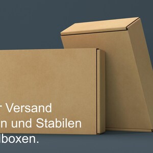 May include: Two brown cardboard boxes stacked on top of each other. The top box is slightly tilted. The bottom box has the text "Sicherer Versand in flachen und stabilen Versandboxen." printed on the front.