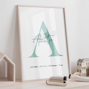 May include: A framed print with a large green letter A and the name "Anita" written in cursive. The print also includes the date "12.07.2023", time "03:17 Uhr", weight "2950 Gramm", and length "50 cm".