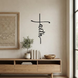 a minimalist living space with a wooden entertainment center, a potted plant, and a framed artwork on the wall.