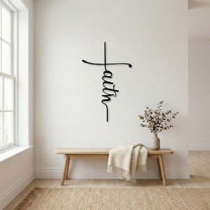 a minimalist interior design with a wooden bench, a vase of greenery, and a wall decoration that reads "Faith" in a cursive font.