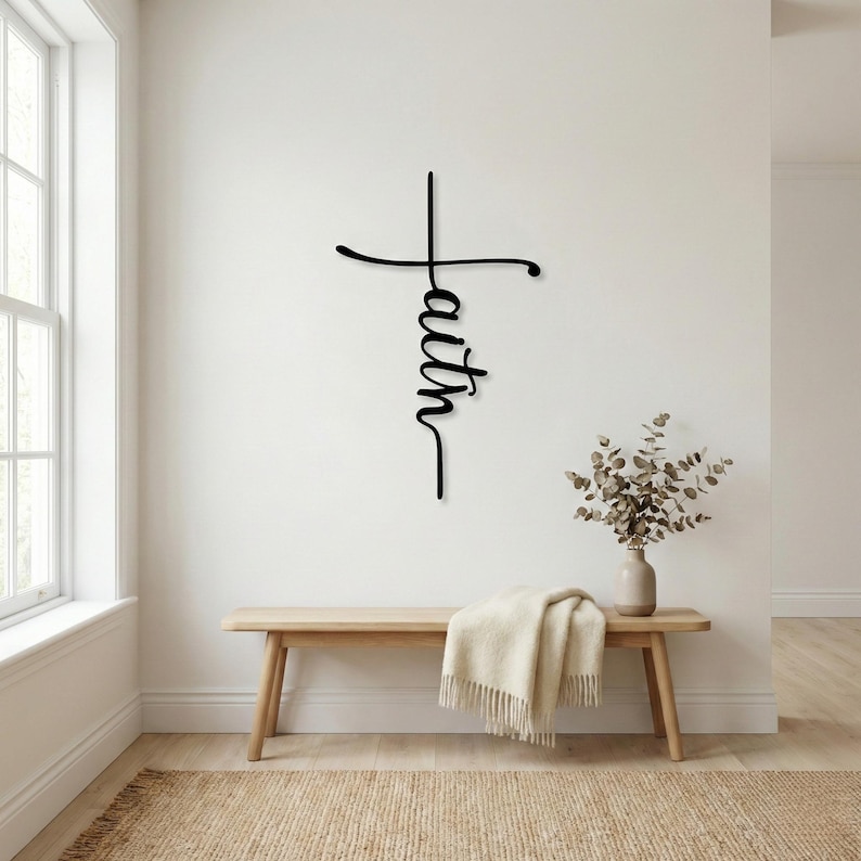 a minimalist interior design with a wooden bench, a vase of greenery, and a wall decoration that reads "Faith" in a cursive font.