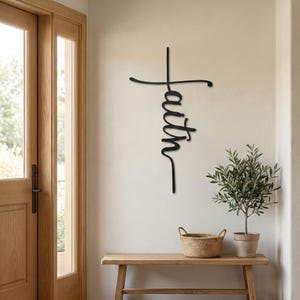 a wooden console table with a woven basket on top, and a potted plant next to it. Above the console table, there is a metal cross-shaped sign with the word "Faith" written on it.