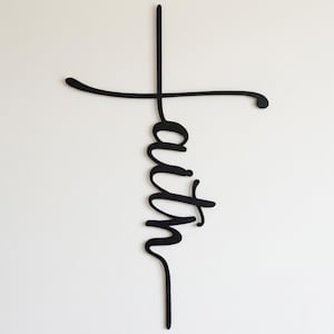 a black cross-shaped sign with the word "Faith" written on it.