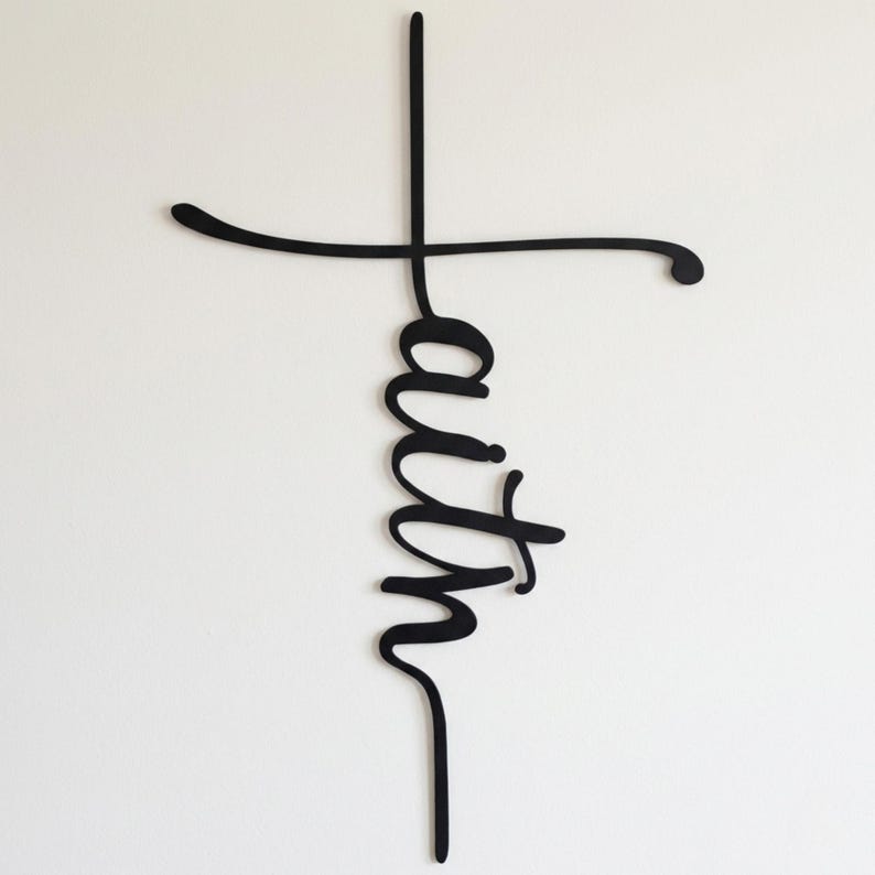 a black cross-shaped sign with the word "Faith" written on it.