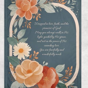 May include: A blue floral throw blanket with a white oval frame containing a Christian quote. The quote reads: "Wrapped in love, faith, and the promises of God. May you always walk in His light, guided by His grace, and rest in the peace of His unending love. You are fearfully and wonderfully made."