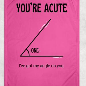 May include: A bright pink rectangular blanket featuring a black graphic of an acute angle. The text at the top reads YOU'RE ACUTE, with -ONE- inside the angle and the phrase I've got my angle on you. printed in black at the bottom of the blanket.