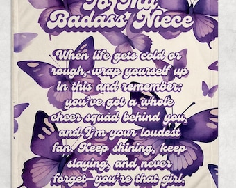 May include: Purple and white throw blanket with a watercolour butterfly pattern. The blanket features the text "To My Badass Niece" and a message about having a cheer squad and being your loudest fan.