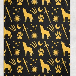 May include: Black blanket with a repeating pattern of gold wolves, paw prints, swords, suns, moons, and stars. The blanket is made of a soft material and is suitable for a bed or couch.