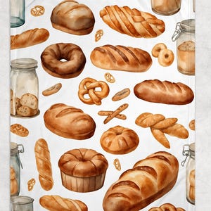 May include: A white blanket featuring a watercolor pattern of various baked goods. The design includes loaves of bread, pretzels, bagels, and jars of flour and bread. The baked goods are in shades of brown and tan, creating a warm, inviting aesthetic.