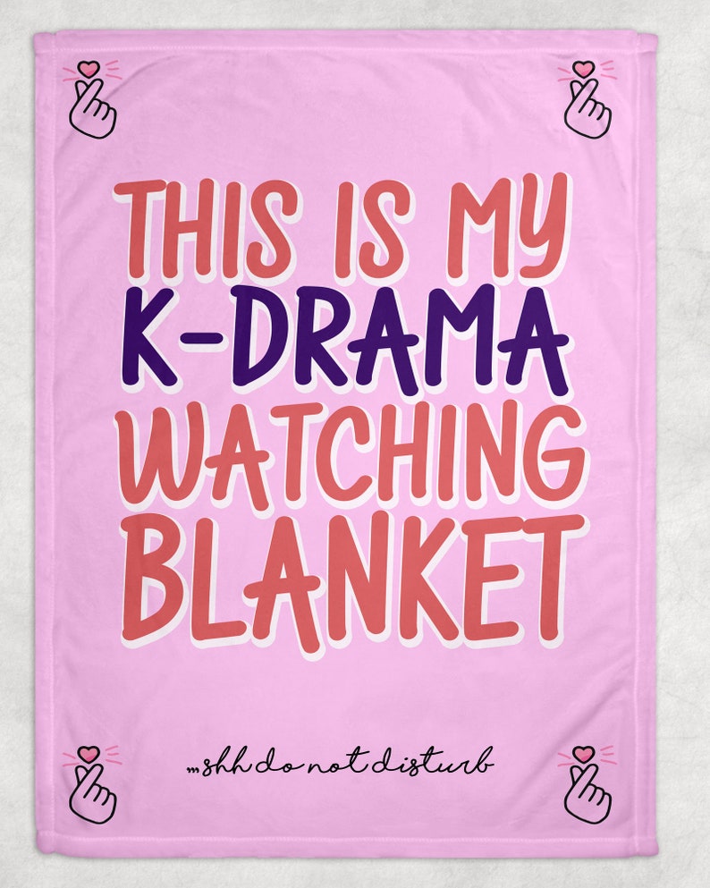 May include: Pink fleece blanket with the text "This is my K-Drama watching blanket" in red and purple lettering. The text "...shh do not disturb" is written in black at the bottom of the blanket.