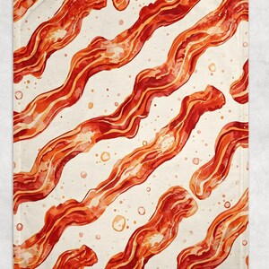May include: A rectangular throw blanket with a repeating pattern of watercolour-style bacon rashers in shades of red and orange on a cream background. The blanket has a soft appearance, ideal for adding a touch of fun to any room.