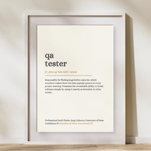 Könnte beinhalten: Ein gerahmter Wanddruck mit einer wörterbuchartigen Definition des Begriffs qa tester. Der Text ist in Dunkelgrau und Orange auf cremefarbenem Hintergrund gedruckt und beschreibt die Rolle als professioneller Fehlersucher und Bug-Sammler.