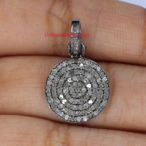 May include: A silver pendant featuring a round, pave-set diamond design. The pendant measures approximately 2.5 cm in diameter and has a bail for attaching to a chain.