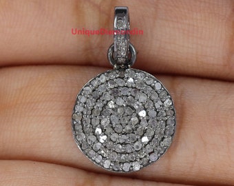 May include: A silver pendant with a round, pave-set diamond design. The pendant is approximately 1 inch in diameter and has a bail for attaching to a chain.