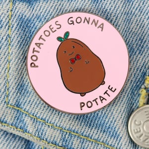 Può includere: Uno spillo in smalto rosa e argento con una patata di cartone animato che indossa un papillon. Il testo sullo spillo recita "Potatoes Gonna Potate".