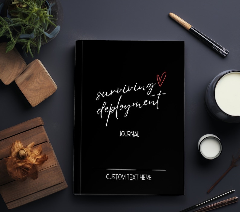 May include: Black journal with the text "surviving deployment" in white cursive script and a red heart. The text "JOURNAL" is below the title and "CUSTOM TEXT HERE" is at the bottom of the cover.