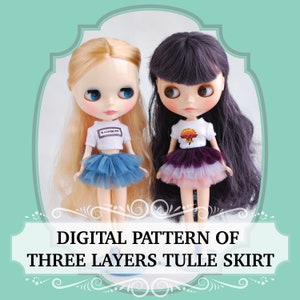 May include: Two dolls wearing white shirts and three-layered tulle skirts. The doll on the left has a blue skirt and the doll on the right has a purple, pink, and white skirt. The doll on the left has blonde hair and the doll on the right has dark purple hair. The text "DIGITAL PATTERN OF THREE LAYERS TULLE SKIRT" is at the bottom of the image.