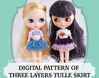 May include: Two dolls wearing white shirts and three-layered tulle skirts. The doll on the left has a blue skirt and the doll on the right has a purple, pink, and white skirt. The doll on the left has blonde hair and the doll on the right has dark purple hair. The text "DIGITAL PATTERN OF THREE LAYERS TULLE SKIRT" is at the bottom of the image.