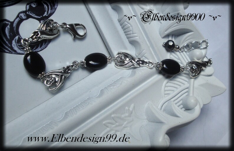 Armband mit schlafenden Fledermäusen und schwarzen Onyx-Perlen.
Karabinerschluss und Verlängerungskettchen mit schwarzer Glasperle am Ende.