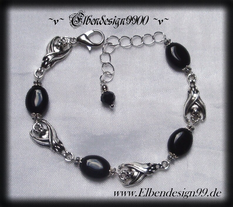 Armband mit schlafenden Fledermäusen und schwarzen Onyx-Perlen.
Karabinerschluss und Verlängerungskettchen mit schwarzer Glasperle am Ende.