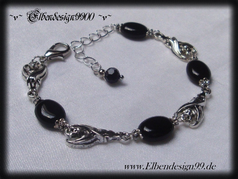 Armband mit schlafenden Fledermäusen und schwarzen Onyx-Perlen.
Karabinerschluss und Verlängerungskettchen mit schwarzer Glasperle am Ende.