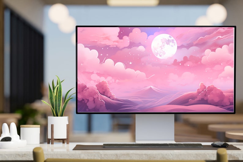 K&ouml;nnte beinhalten: Ein Computermonitor zeigt eine rosa und violette Landschaft mit einem gro&szlig;en, wei&szlig;en Mond und Sternen. Der Monitor steht auf einem Schreibtisch mit einer Pflanze in einem wei&szlig;en Topf und einer Tastatur.