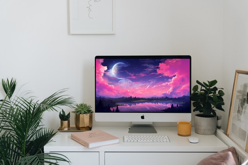 K&ouml;nnte beinhalten: Ein wei&szlig;er Desktop-Computer mit einer rosa und violetten Landschafts-Tapete, die einen Halbmond und Sterne zeigt. Der Computer steht auf einem wei&szlig;en Schreibtisch mit einer Tastatur, einem Buch und einer Topfpflanze.