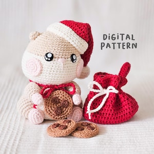 Puede incluir: Un h&aacute;mster de ganchillo con un gorro de Pap&aacute; Noel y una galleta. El h&aacute;mster es beige y blanco con mejillas rosadas. Tambi&eacute;n hay una bolsa roja con cord&oacute;n y dos galletas. El texto "DIGITAL PATTERN" es visible.