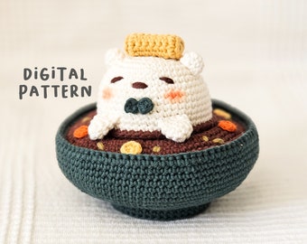 May include: A crocheted amigurumi toy of a white bear wearing a yellow hat and a green bow tie, sitting in a green bowl with brown and orange details.