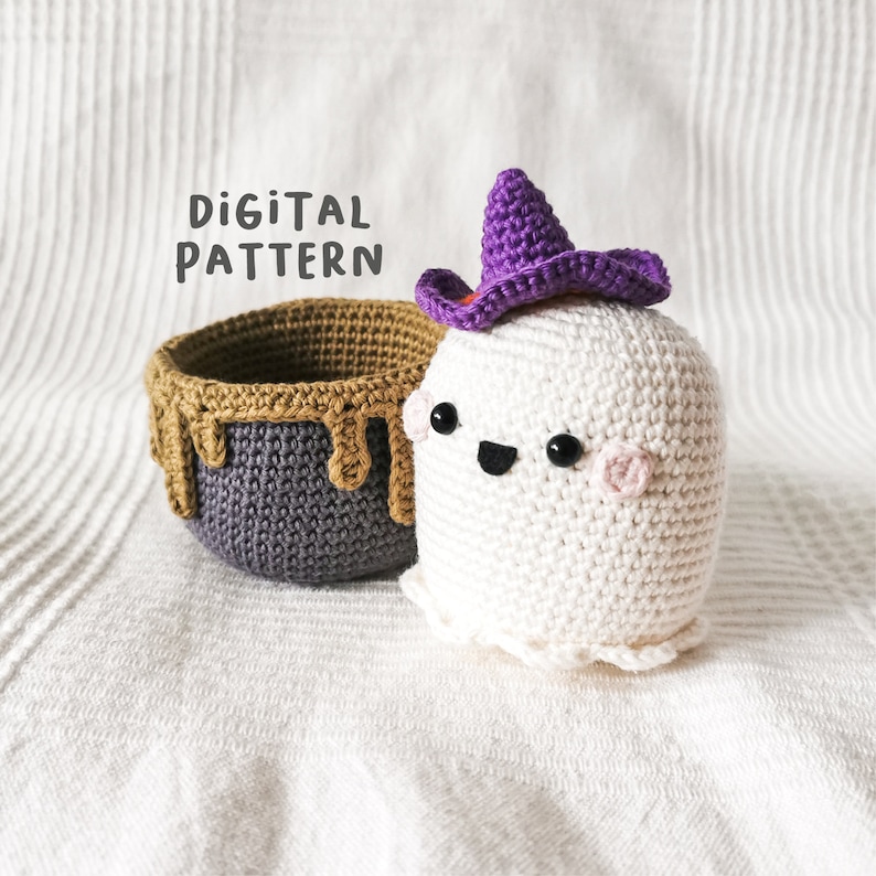 May include: Crochet pattern for a ghost wearing a purple witch hat and a brown and purple cauldron. The pattern is called "Digital Pattern".