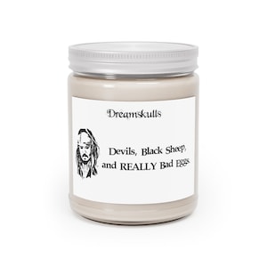 May include: A white candle jar with a silver lid. The label features a black and white illustration of Captain Jack Sparrow from the Pirates of the Caribbean movies. The text on the label reads "Dreamskulls, Devils, Black Sheep, and REALLY Bad Eggs."