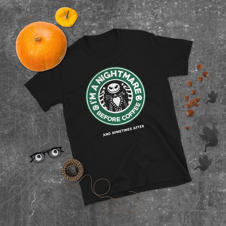 May include: Black t-shirt featuring a green and white logo that reads "I'm a Nightmare Before Coffee" and depicts a cartoon character. The text beneath the logo says "And Sometimes After."