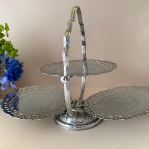 以下が含まれることがあります： 黒いハンドルと「But First, Coffee」のテキストが黒い太字で書かれた白いセラミックマグ。マグは白い表面に置かれています。