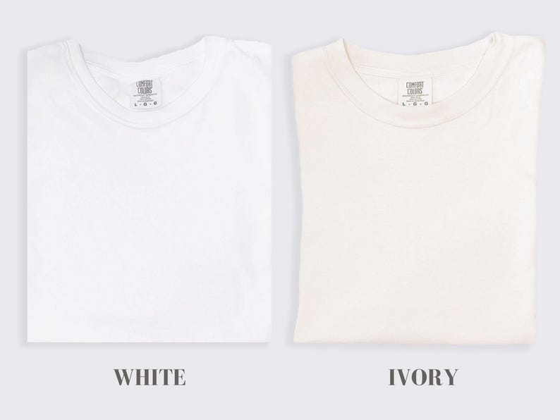 May include: Two plain t-shirts, one white and one ivory, both with a small tag that reads "Comfort Colors" and "L/G".