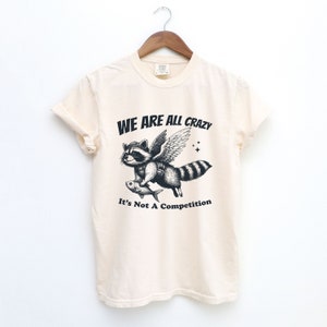 Camisa estranha engraçada, camiseta retrô, camiseta gráfica minimalista de guaxinim angustiado vintage, camisa engraçada dos anos 90, camiseta unissex com mordaça vintage