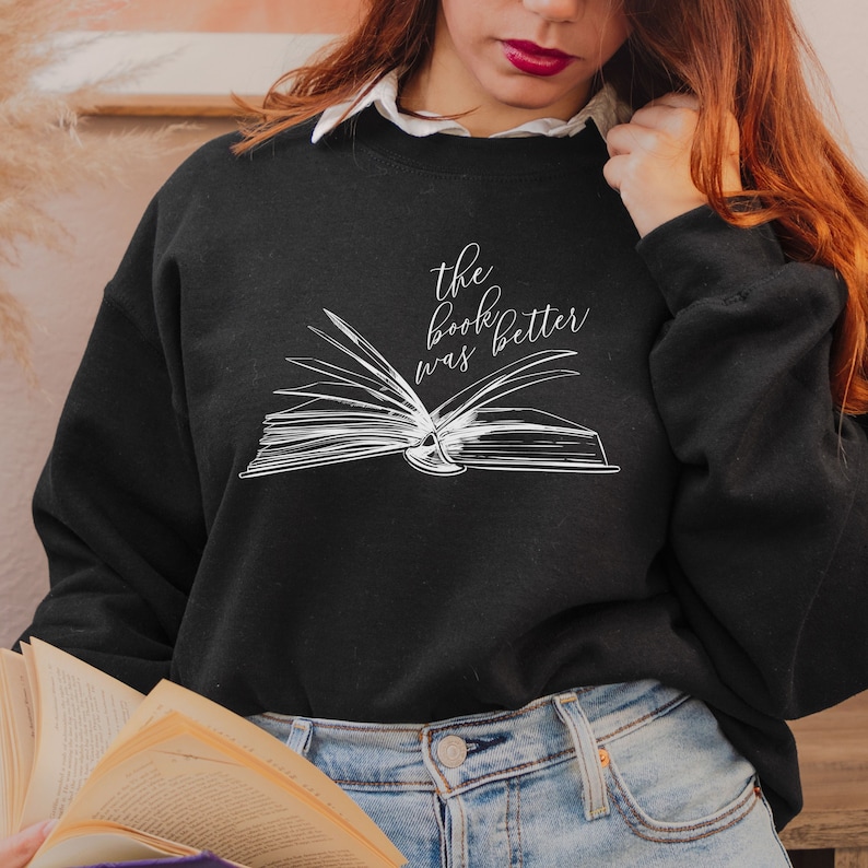 May include: Black sweatshirt with a white graphic of an open book and the text "the book was better".