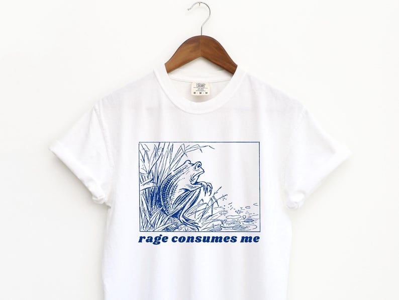 May include: White t-shirt with a blue illustration of a frog in a pond and the text "rage consumes me" printed on the front.